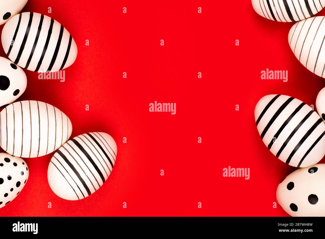 Different graphic hand-painted eggs on bright red background. Easter concept. Place for text. Stock Photo