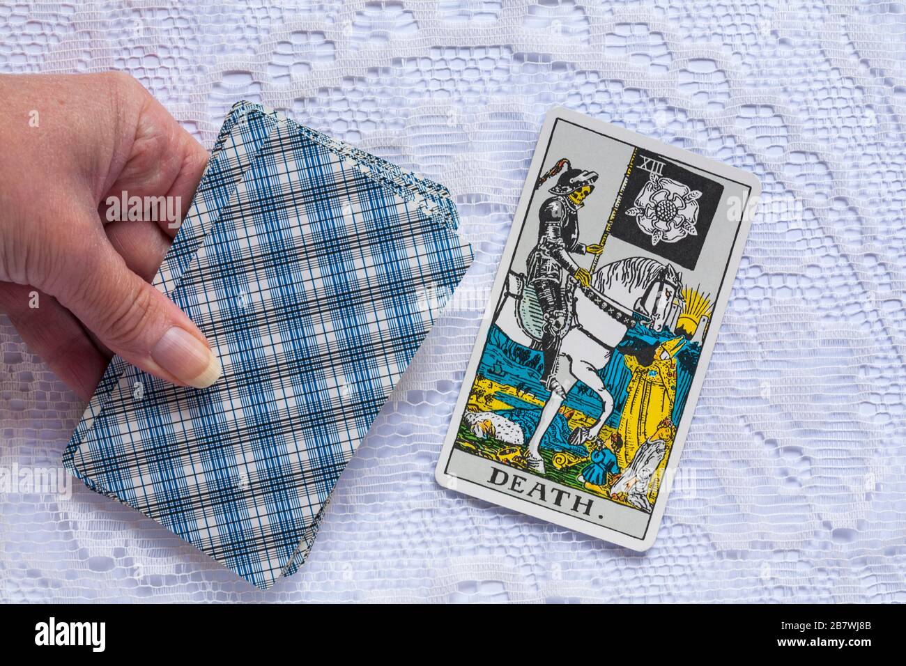 hand holding Rider Tarot Cards designed by Pamela Colman Smith under supervision of Arthur Edward Waite with Death tarot card upturned Stock Photo