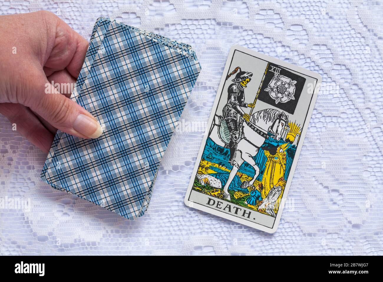 hand holding Rider Tarot Cards designed by Pamela Colman Smith under supervision of Arthur Edward Waite with Death tarot card upturned Stock Photo