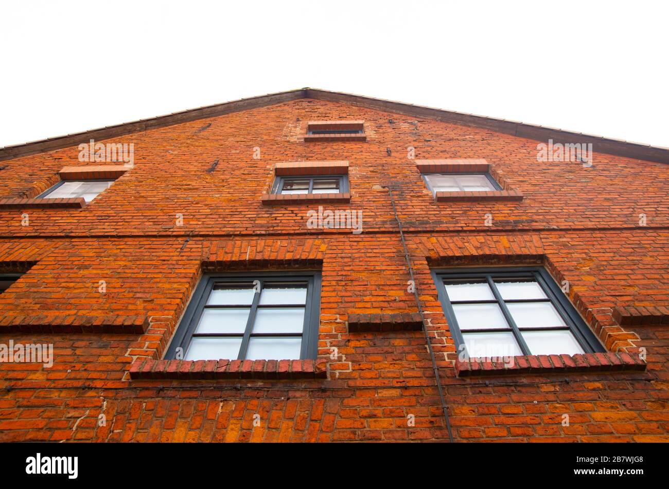 Old brick house, view up. Brick building not repaired in the historic center of the German city. Typical buildings of old masons attract tourists. Stock Photo
