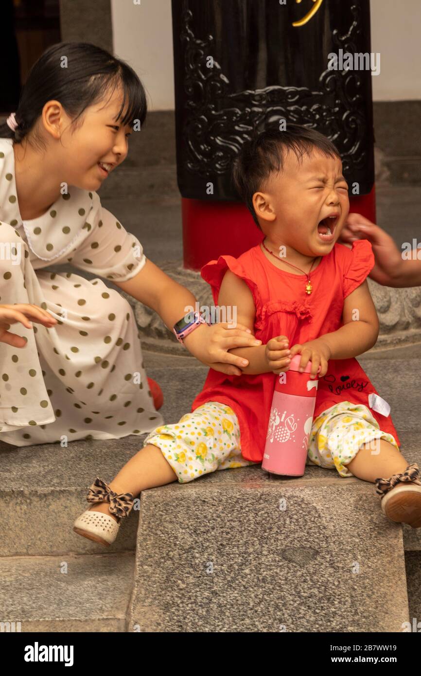 sister comforting toddler brother, Xian, China Stock Photo