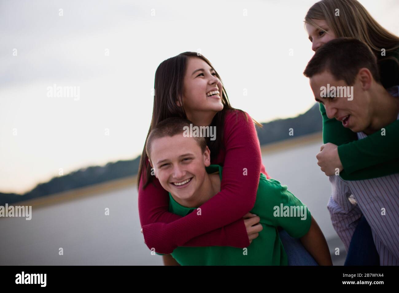 Teenage boy giving girl piggyback hires stock photography and images