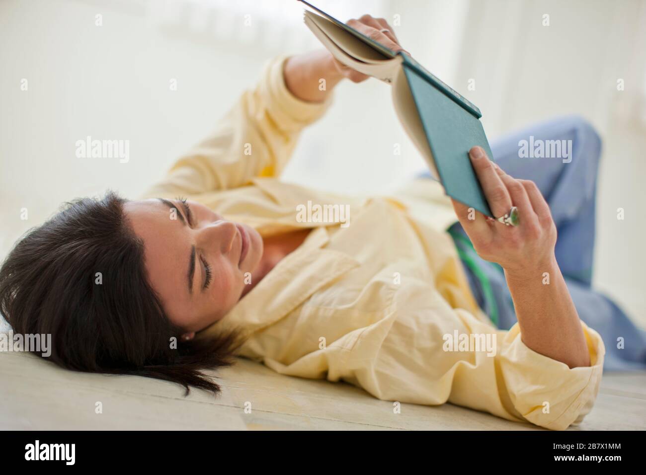 Happy mid adult woman relaxing with a book. Stock Photo
