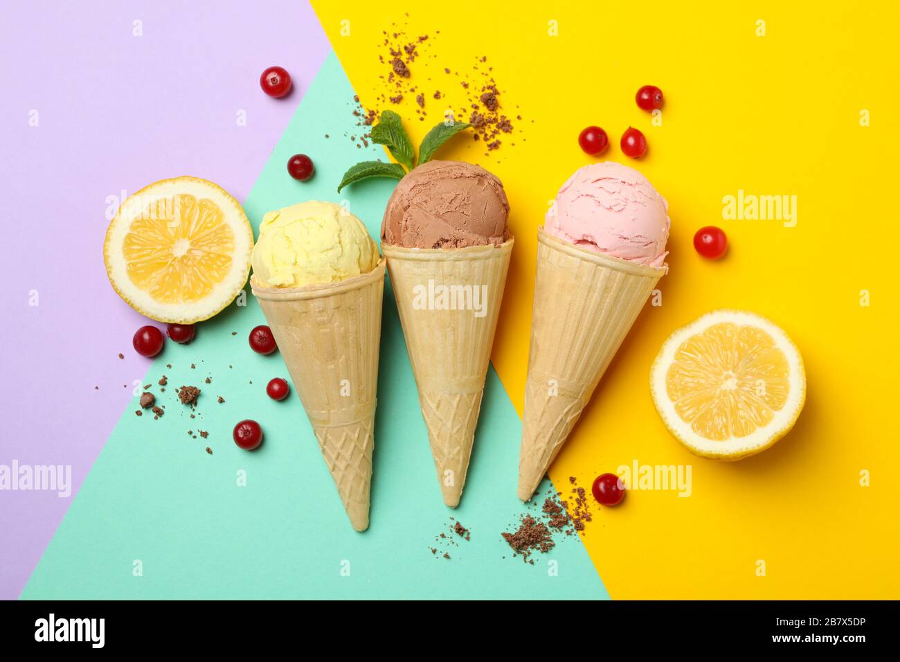 Ice cream in cones, lemon and cranberry on multicolor background. Sweet