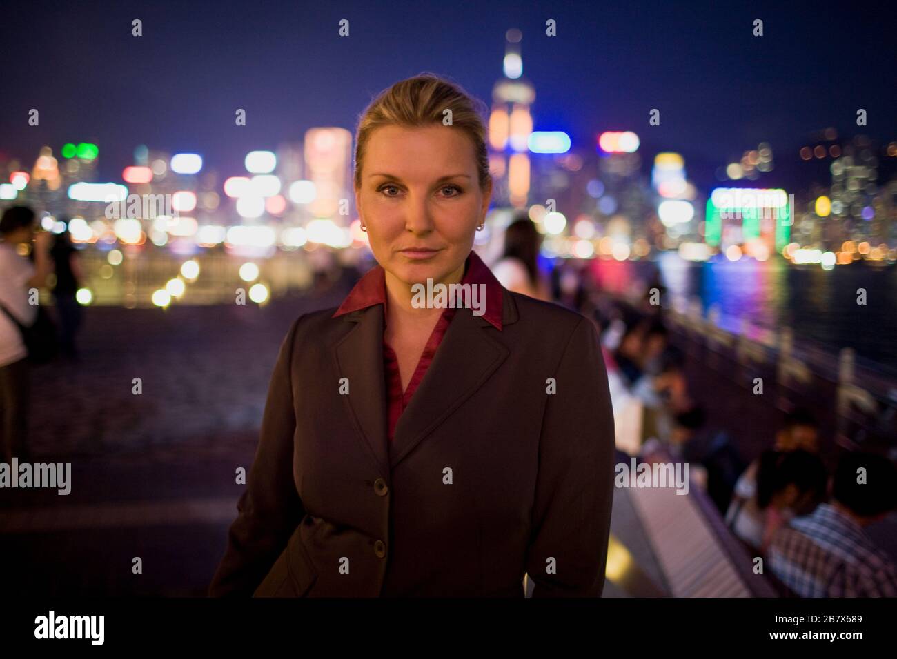 Portrait of a mid-adult business woman standing in the city at night. Stock Photo