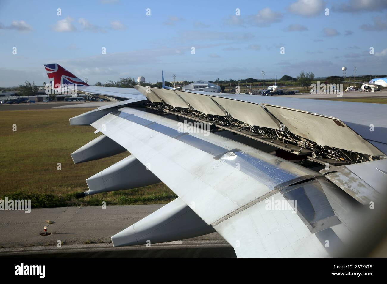 Barbados Boeing 747-400 (744)   Wing Showing Flaps Up Through Aeroplane Window - Plane coming into Land at Grantly Adams International Airport Stock Photo