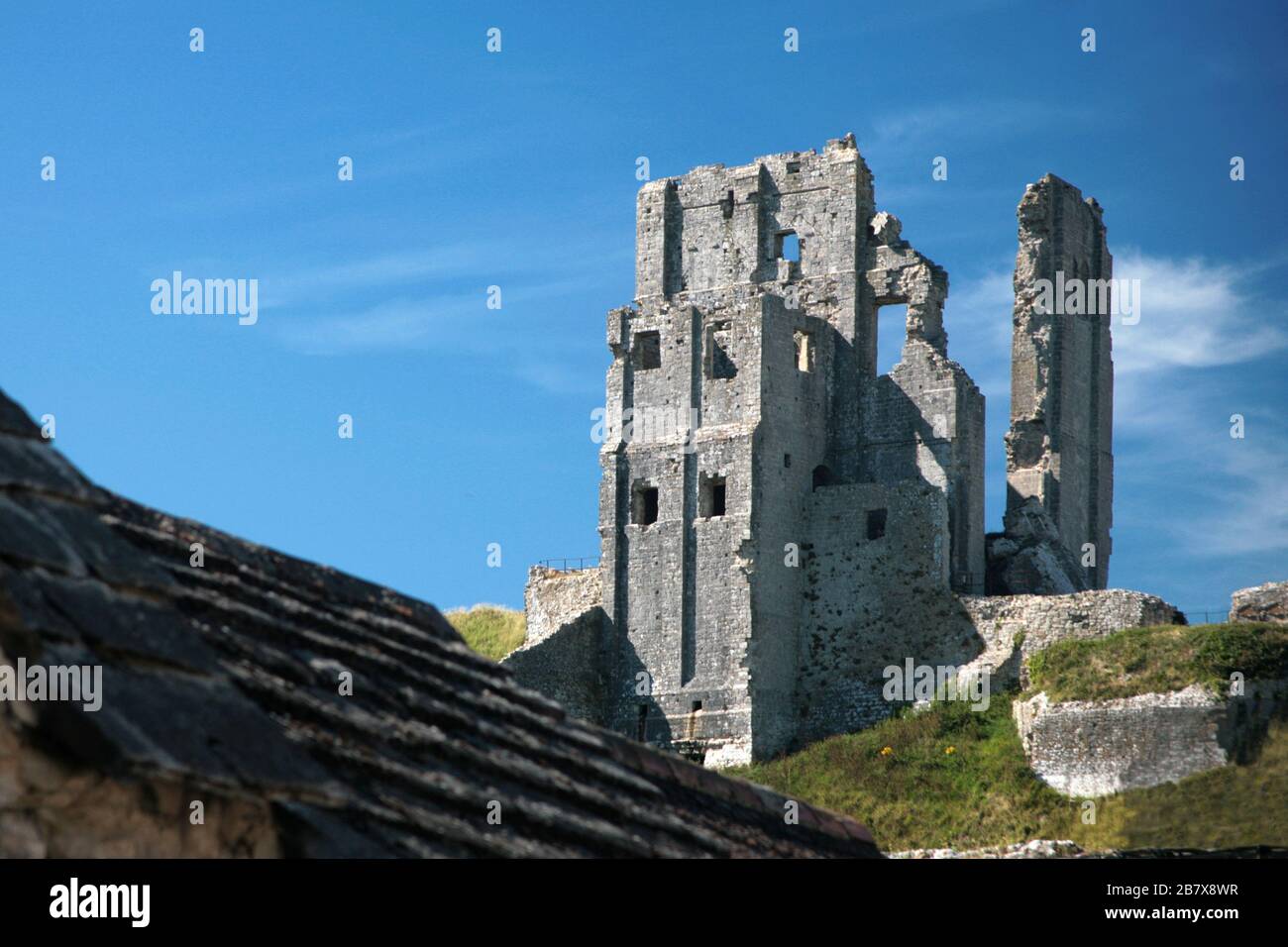 Corfe Castle across the village roofs from the south, Isle of Purbeck, Dorset Stock Photo