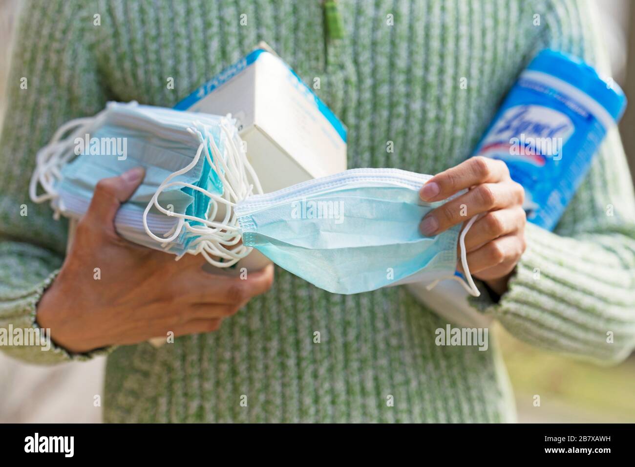 Holding Face Masks and Disinfecting Wipes, to protect from COVID-19, Coronavirus infection Stock Photo
