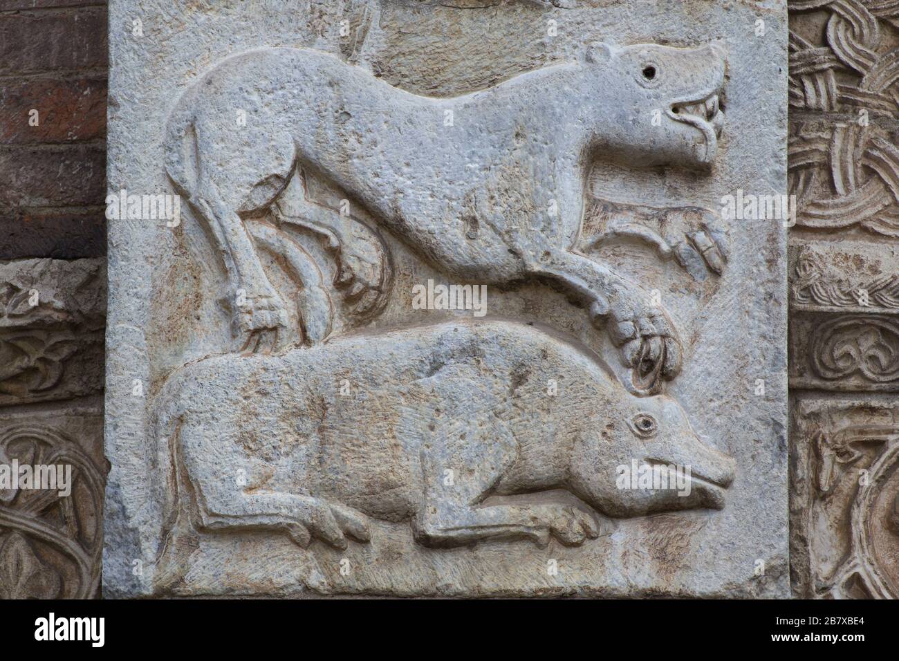 The Medieval Bestiary - Lion and Wild Pig - romanesque bas-relief - - Atrium of Ansperto - Basilica of Sant'Ambrogio - Milan Stock Photo