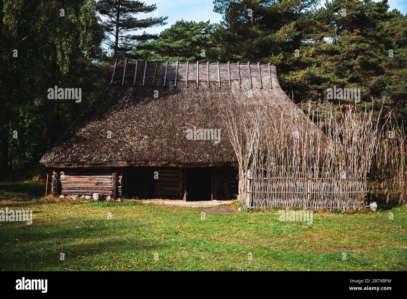 Estonian traditional vernacular architecture with straw thatched roof and log walls Stock Photo