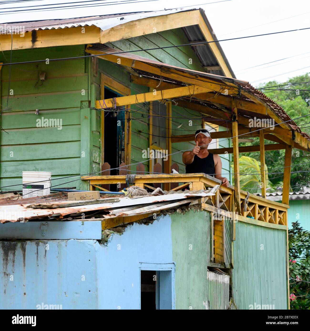 Man showing thumbs up sign from his house, Coxen Hole, Gravel Bay, Roatan, Honduras Stock Photo