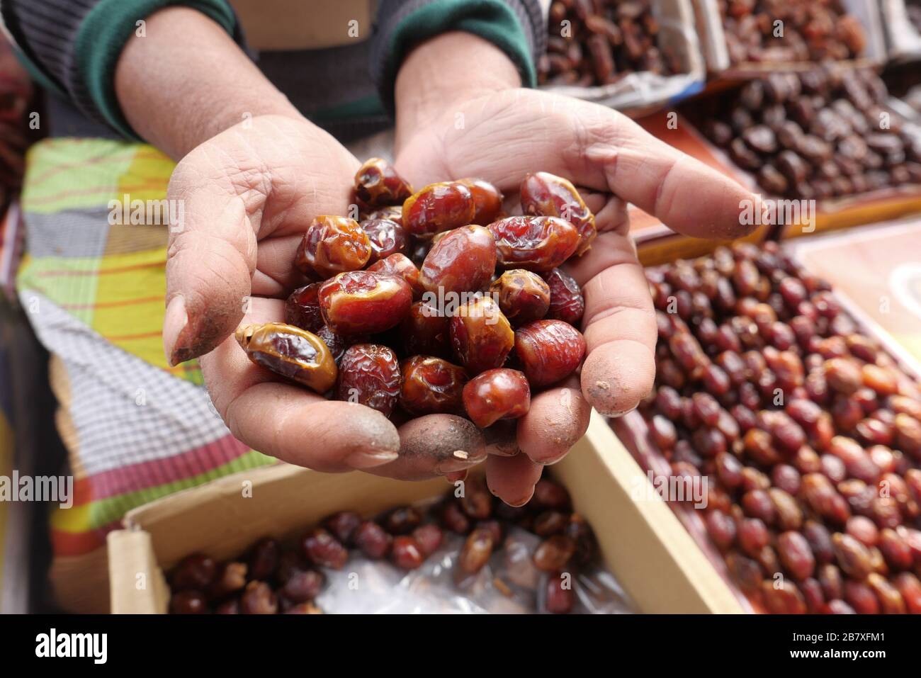 man hand holding date fruit for sale  Stock Photo
