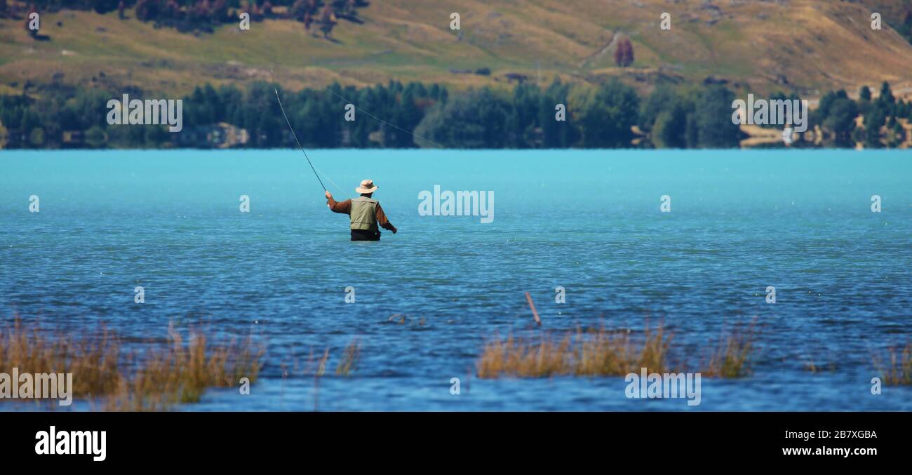 Fisherman in New Zealand lake Stock Photo
