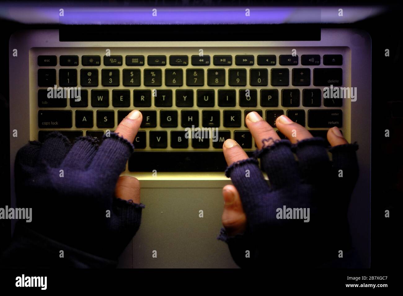 hooded hacker stealing data from laptop at night  Stock Photo