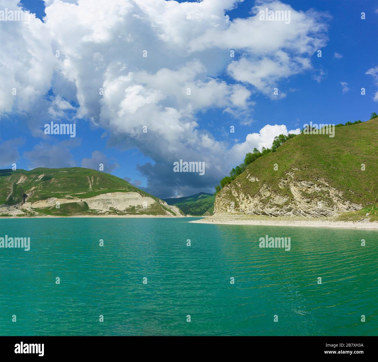 A large white Cumulus cloud rises above the highmountain lake Kezenoi