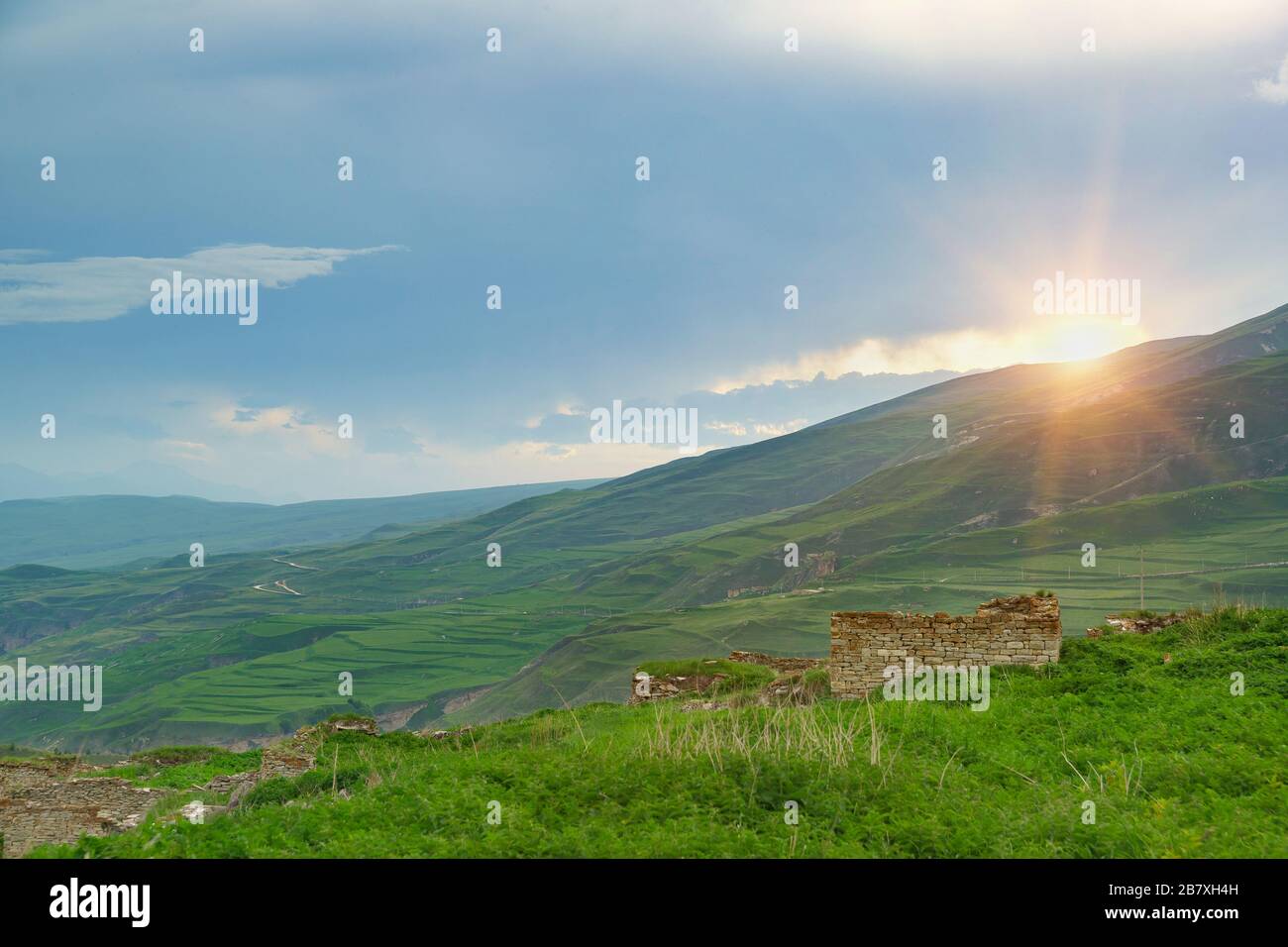 Ruins of the ancient settlement of Hoi against the backdrop of the picturesque mountains of the Greater Caucasus. Cloudy summer evening Stock Photo