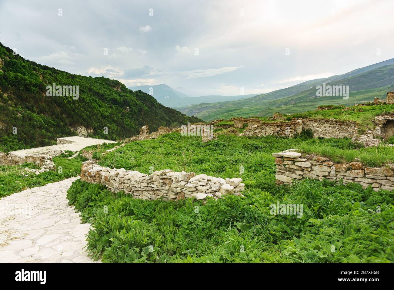 Ruins of the ancient settlement of Hoi against the backdrop of the picturesque mountains of the Greater Caucasus. Masonry without mortar. Cloudy summe Stock Photo