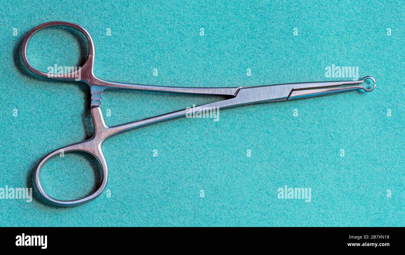 Modern vasectomy forceps used in non scalpel vasectomy operations against a green background. Stock Photo