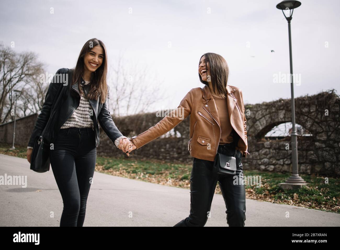 Beautiful women holding hands and smiling outdoors Stock Photo - Alamy