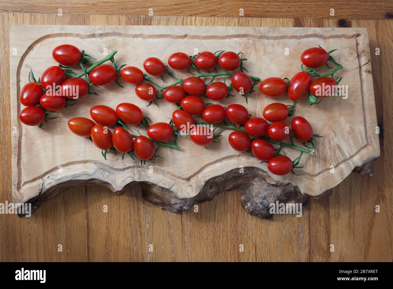 Tomatoes on a vine in a kitchen setting Stock Photo