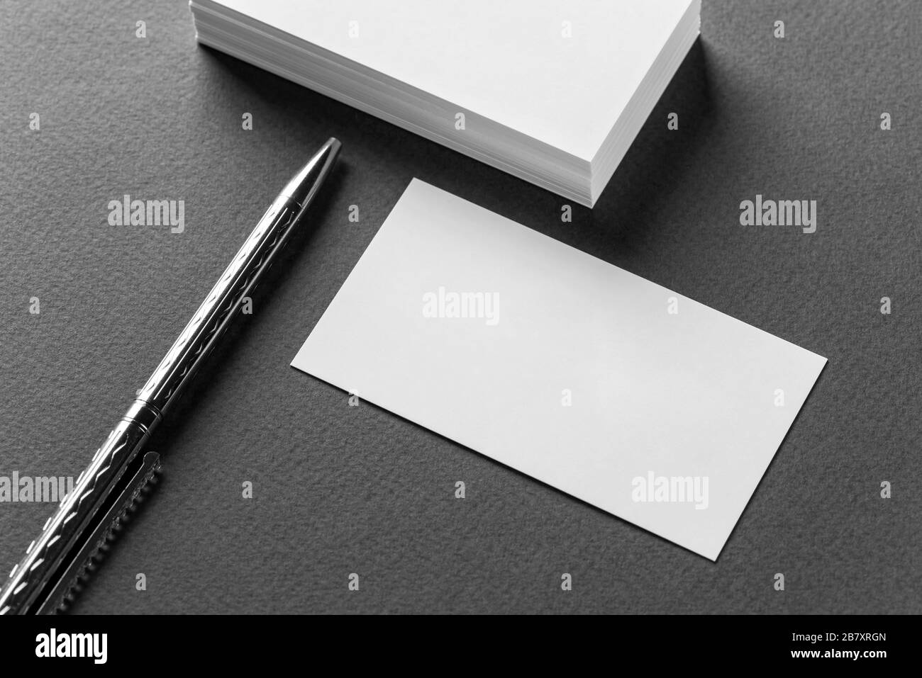 Mockup of business cards stacks arranged in rows and pen on a grey background. Stock Photo