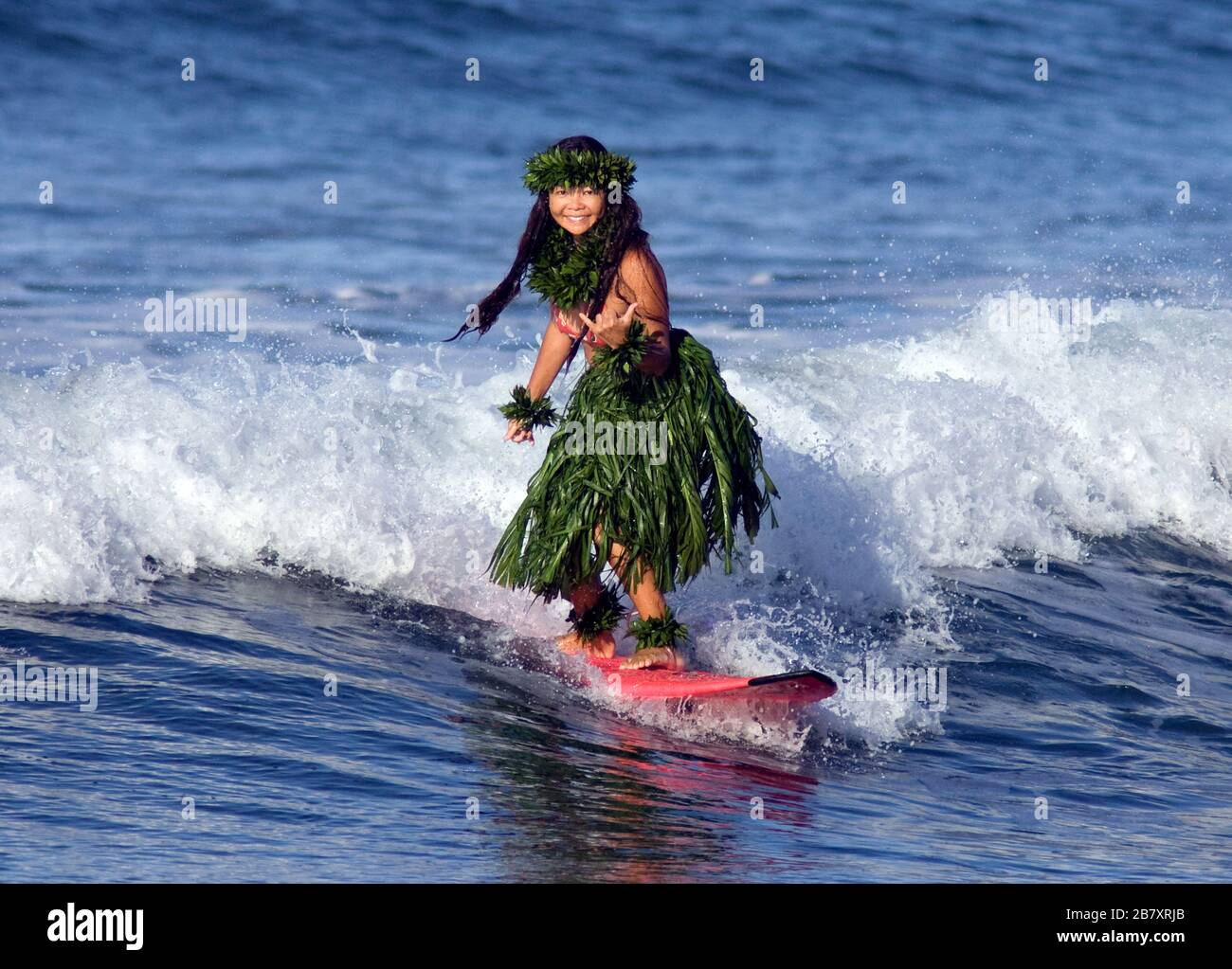 Hula dancer surfs at Launiupoko, Maui, Hawaii. Stock Photo