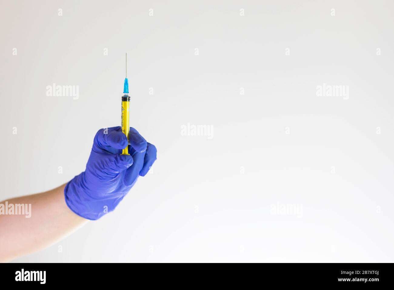 Doctor hand in blue glove holding syringe for vaccine. Medical injection. Cosmetology, health, coronavirus concept. n-CoV-2019 treatment. Pharmacy, la Stock Photo