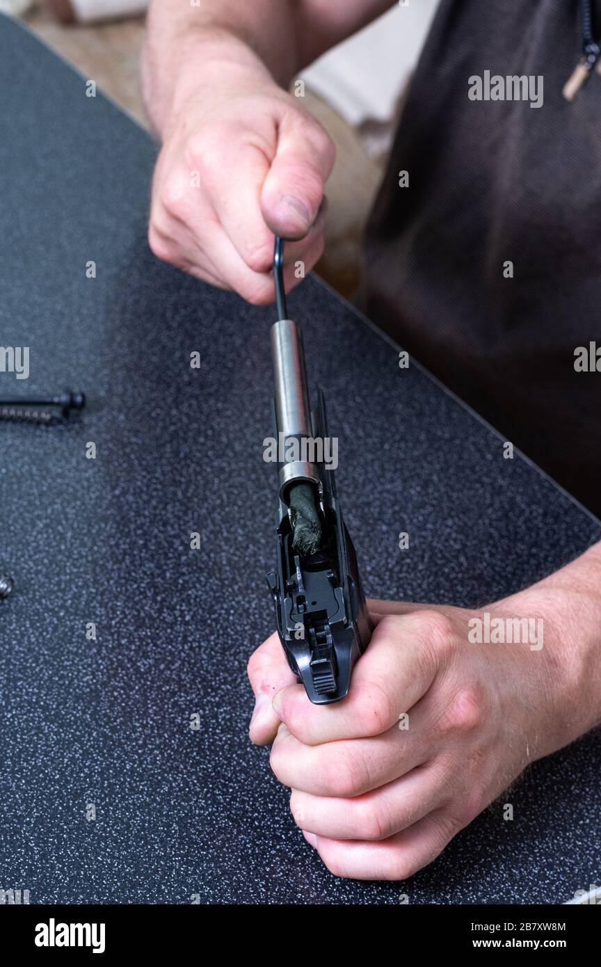 Gun cleaning. Cleaning the gun barrel. The gun in the hands. Vertical