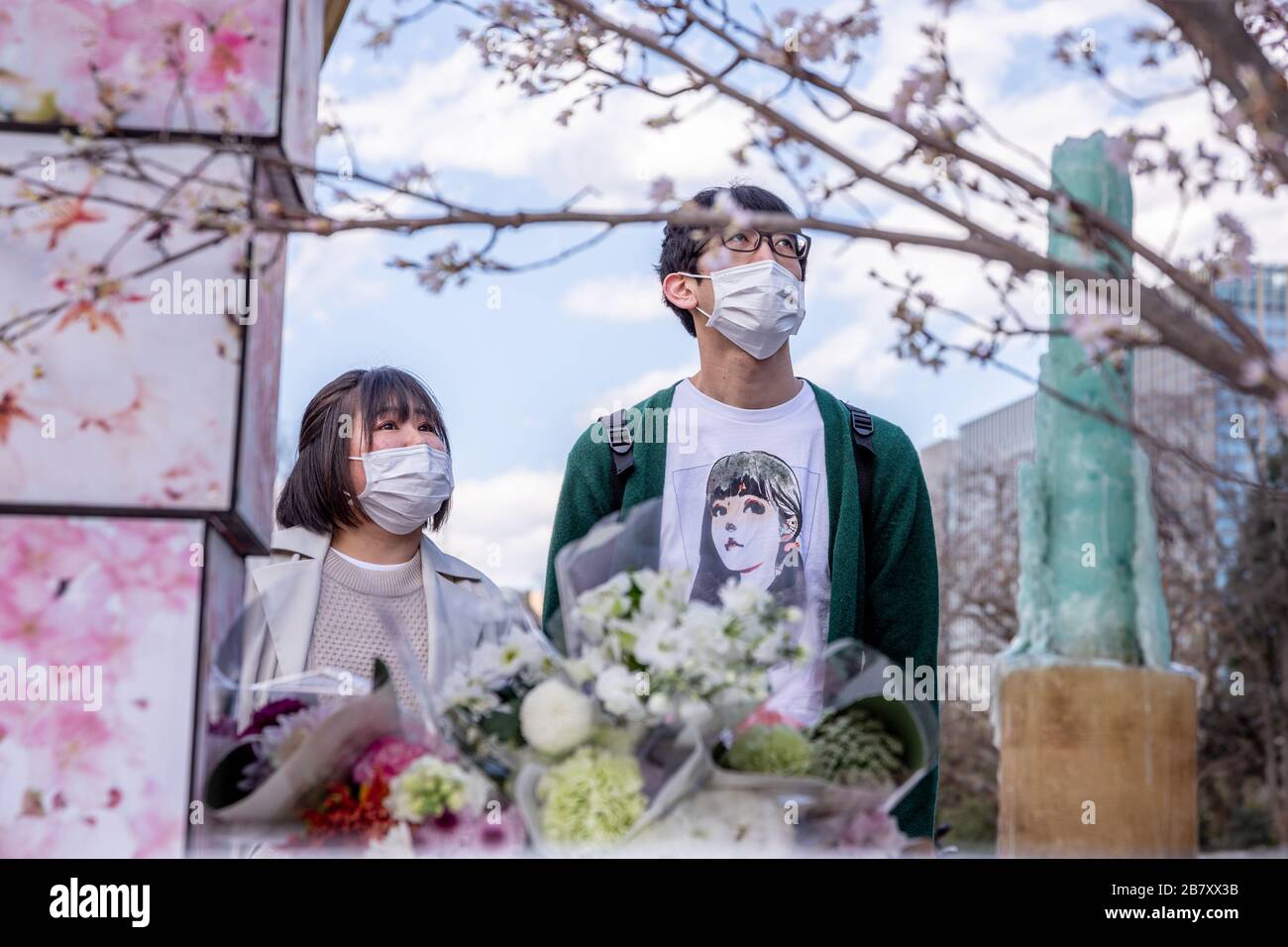 A couple wearing masks as a preventive measure, praying at the 9th anniversary of the 311 mega-earthquake and tsunami during the corona virus pandemic.Concerns are growing about the increasing cases of Coronavirus (COVID-19) in Japan. Many countries have closed borders to Japan and the growing epidemic has caught public attention on the true number of coronavirus cases in Japan that could be much higher. Stock Photo