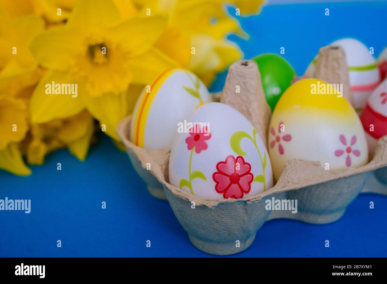 Happy Easter. Easter holiday decorations on trendy colored classic blue background. Creative spring composition with Easter elements - flowers and egg Stock Photo