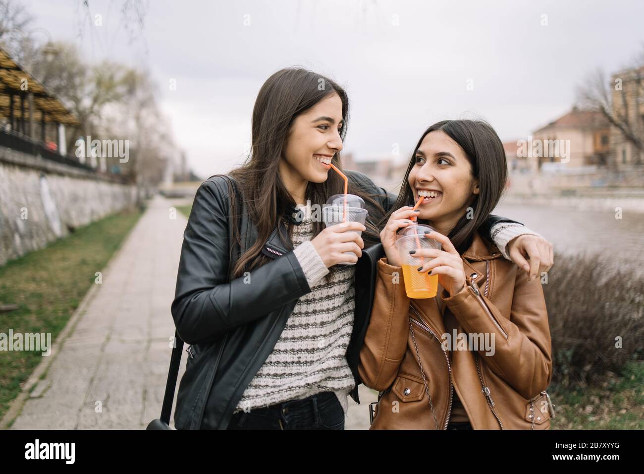 Girls drinking juice while walking in the city Stock Photo Alamy