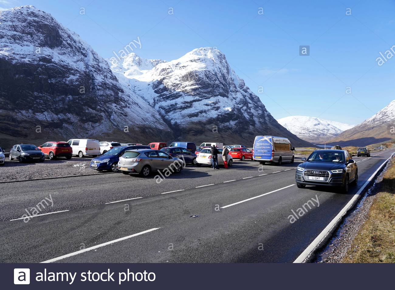 Sun and snow in the Scottish Highlands, A82 road at Glencoe seen here being affected. Visitors carpark at the Three sisters ridge. Scotland. Stock Photo