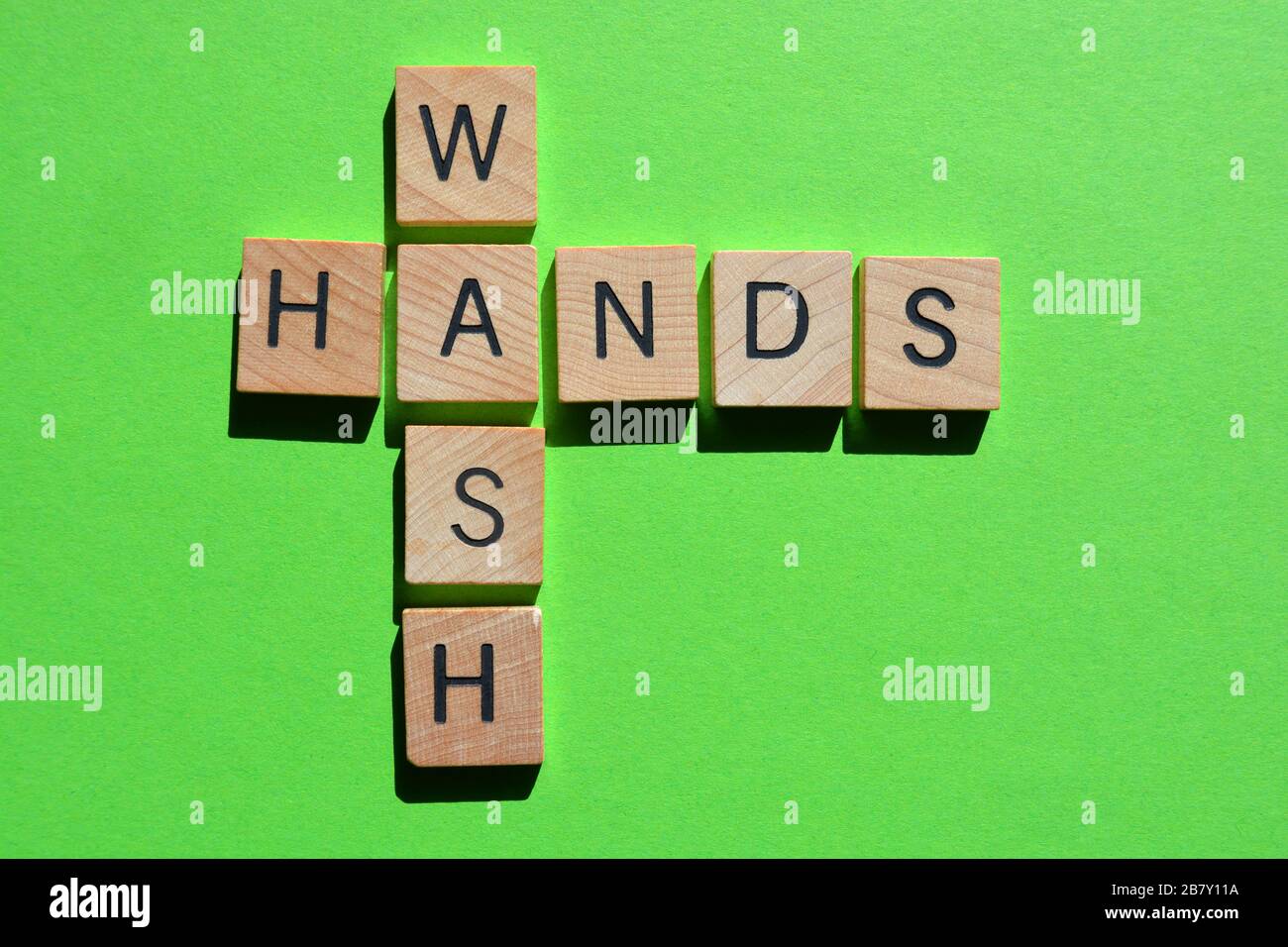 Wash Hands, words in 3d wooden alphabet letters on green background Stock Photo