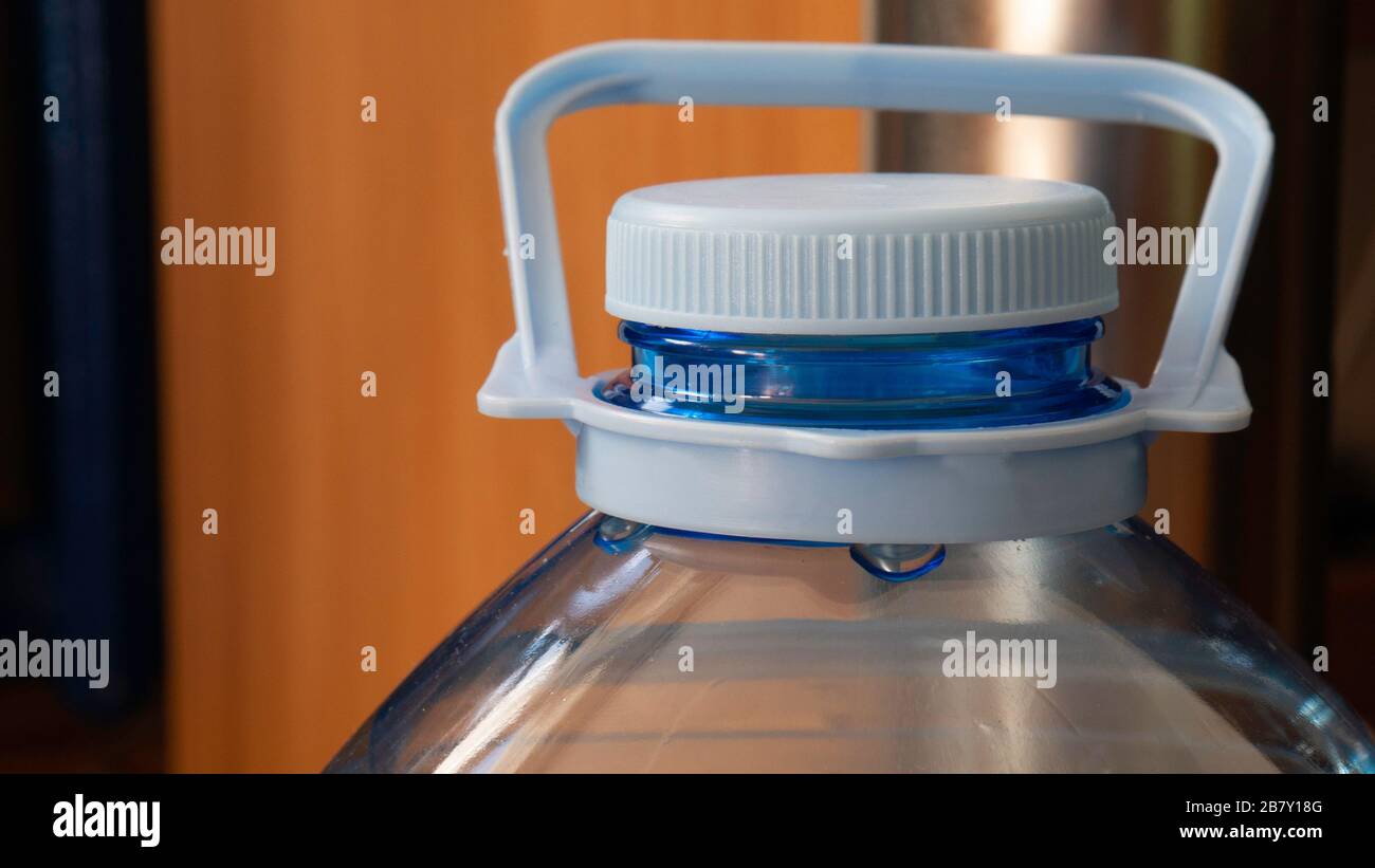 Five liter bottle - close up. Plastic container with water. Blue plastic bottle stopper. Stock Photo