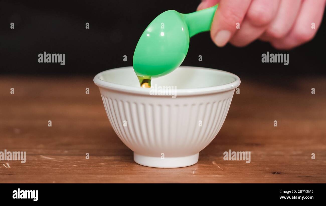 Step by step. Measuring olive oil with a tablespoon Stock Photo Alamy