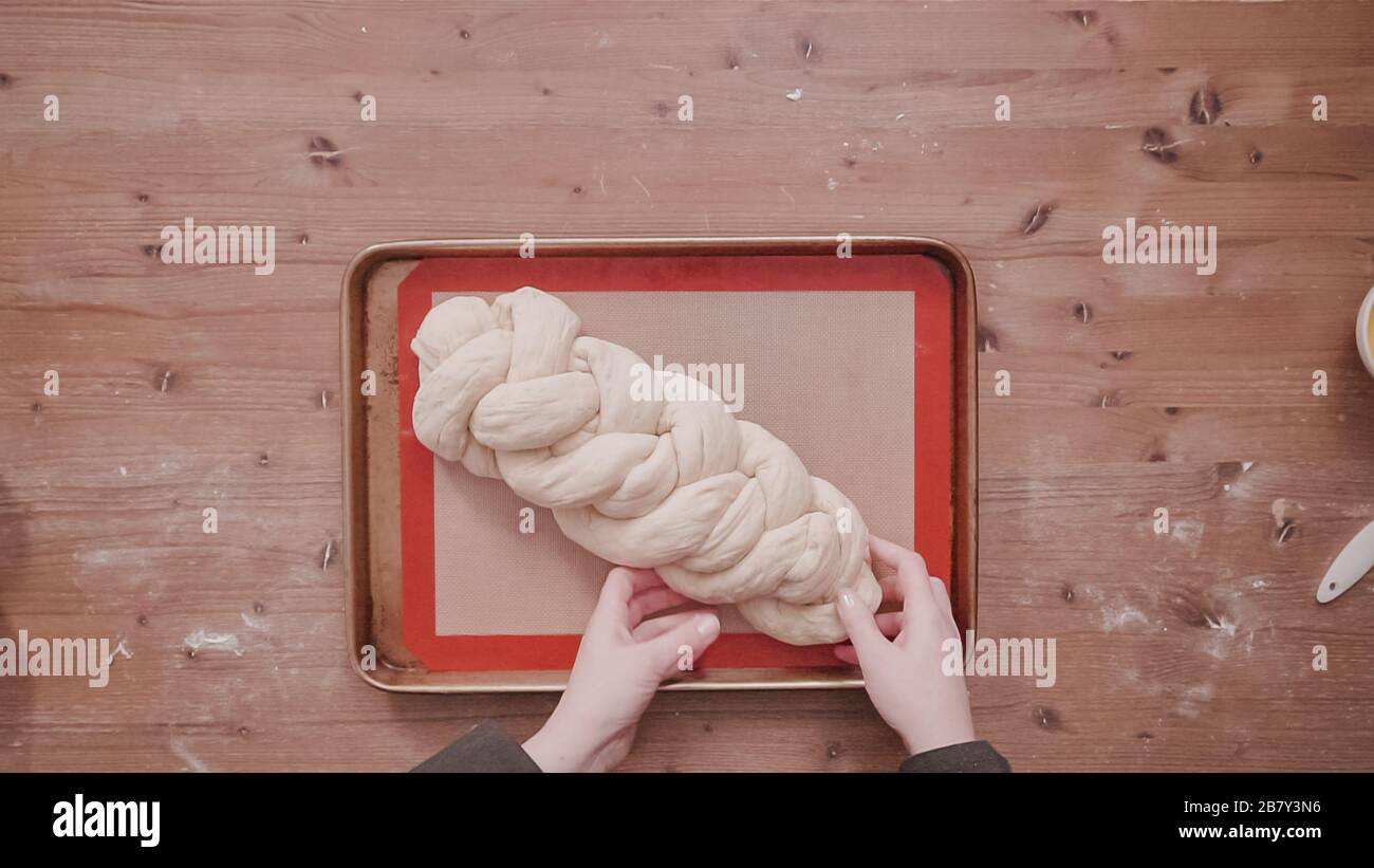 Flat lay. Step by step. Braded challah dough in loaf of bread on baking