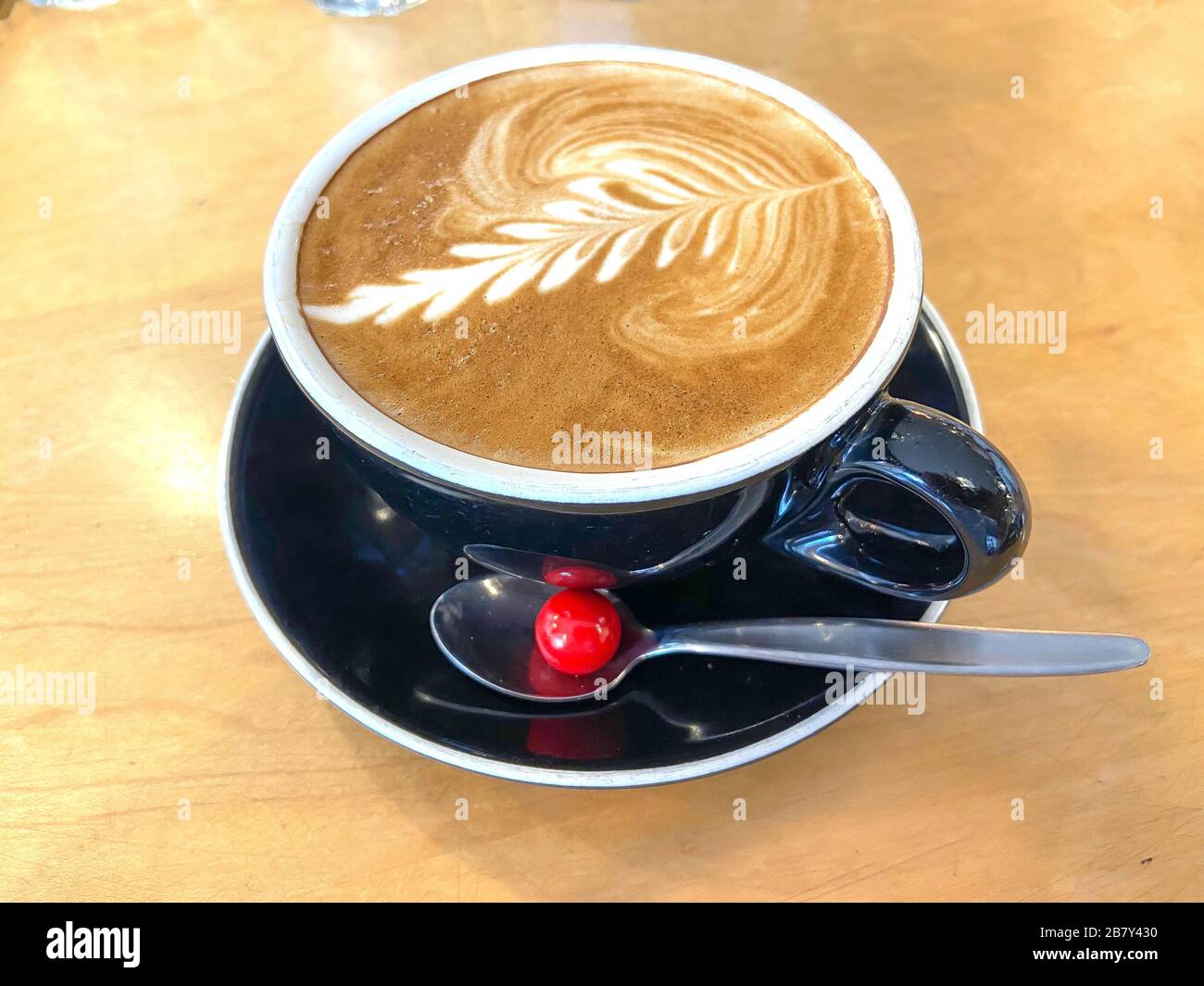 Flat white coffee with Jaffa sweet in coffee house, Christchurch Central, Christchurch, Canterbury Region, New Zealand Stock Photo