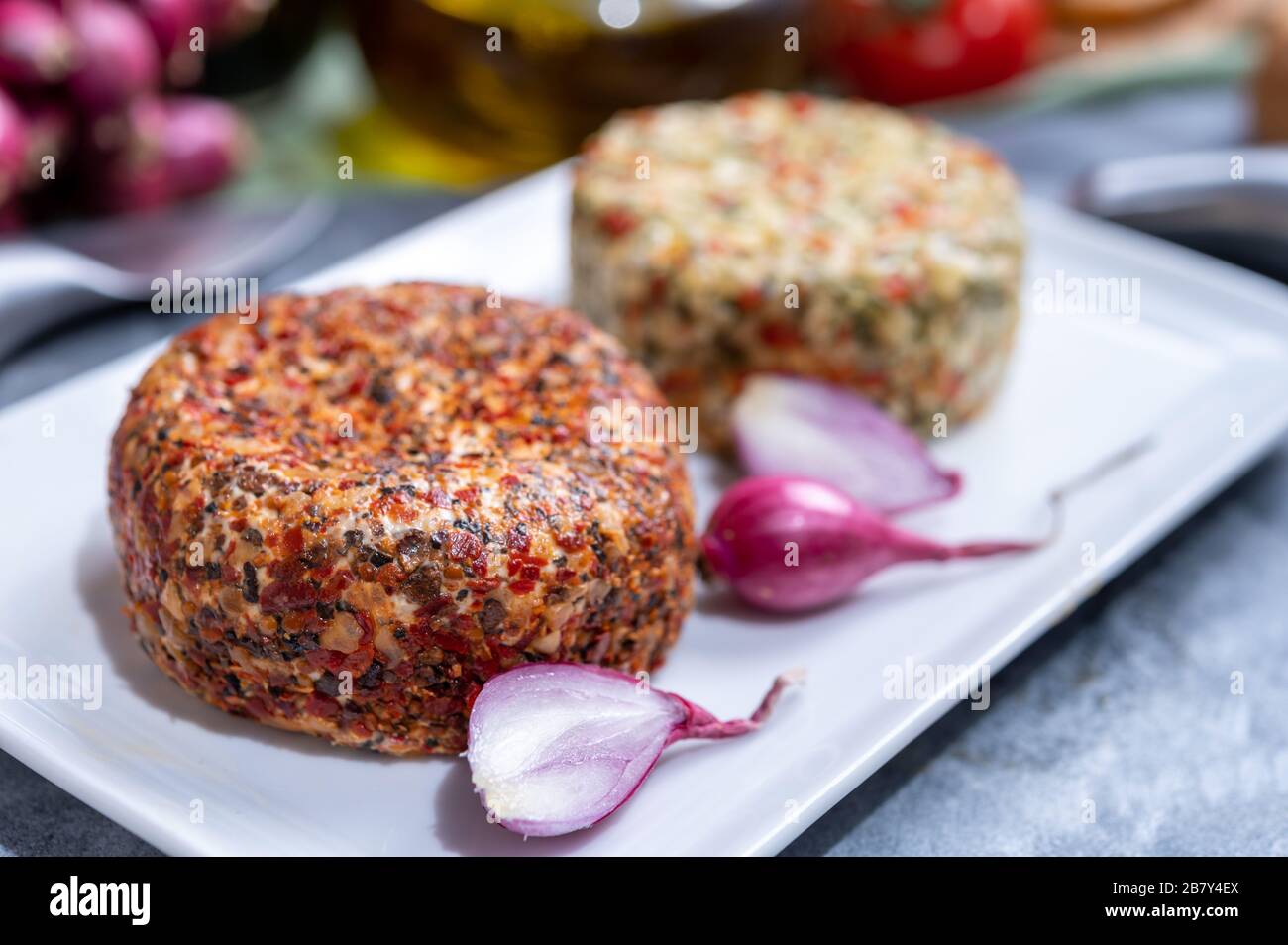 Different french soft goat cheeses made with colorful spices and herbs