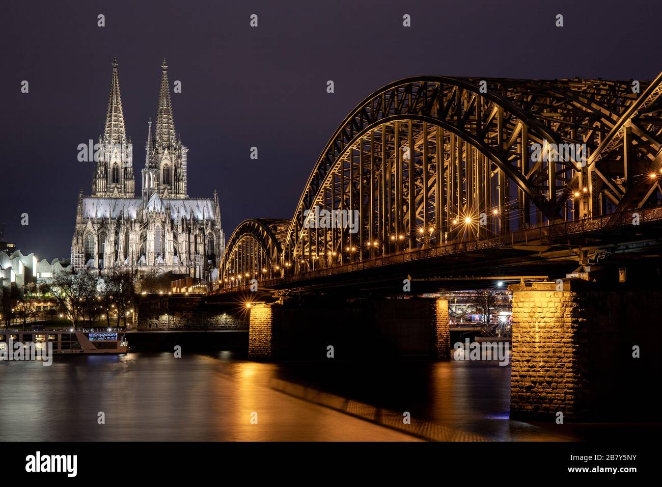 Cologne Cathedral and Hohenzollern Bridge Lit at Night with Starburst Stock Photo