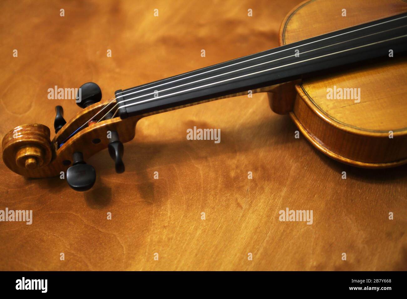 The violin lies on a wooden table, close-up Stock Photo