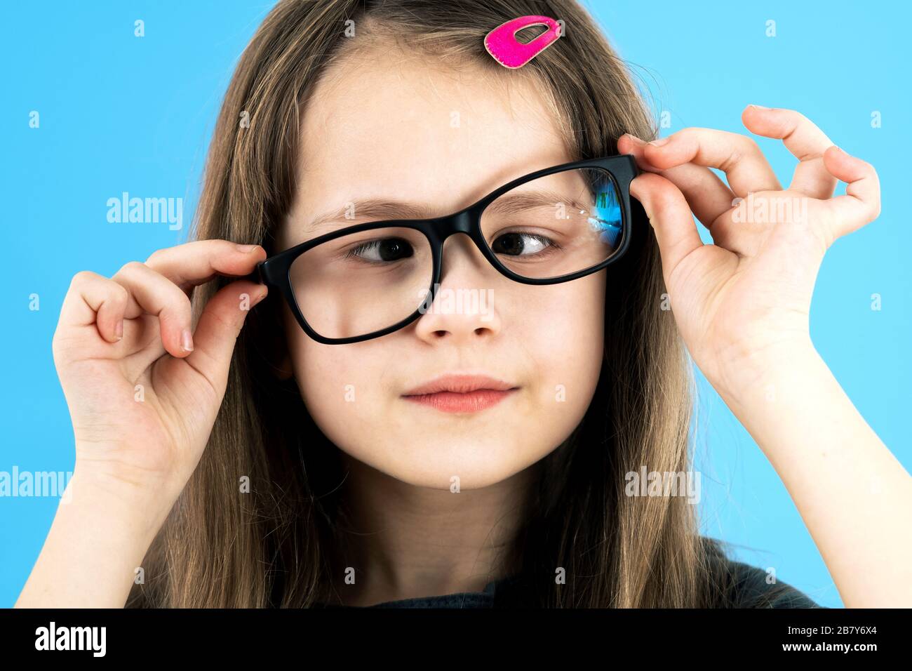Close up portrait of a cross eyed child school girl wearing looking