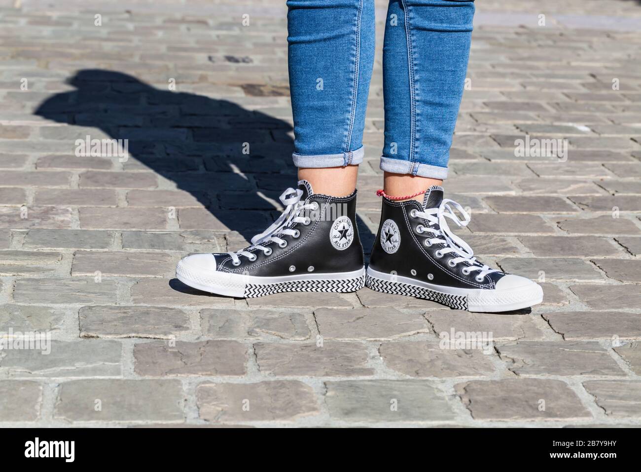 Chartres, France - Spetember 2, 2019: Image of the lower part of teenager's  legs in jeans and All Star Converse sneakers in a cobblestone street Stock  Photo - Alamy