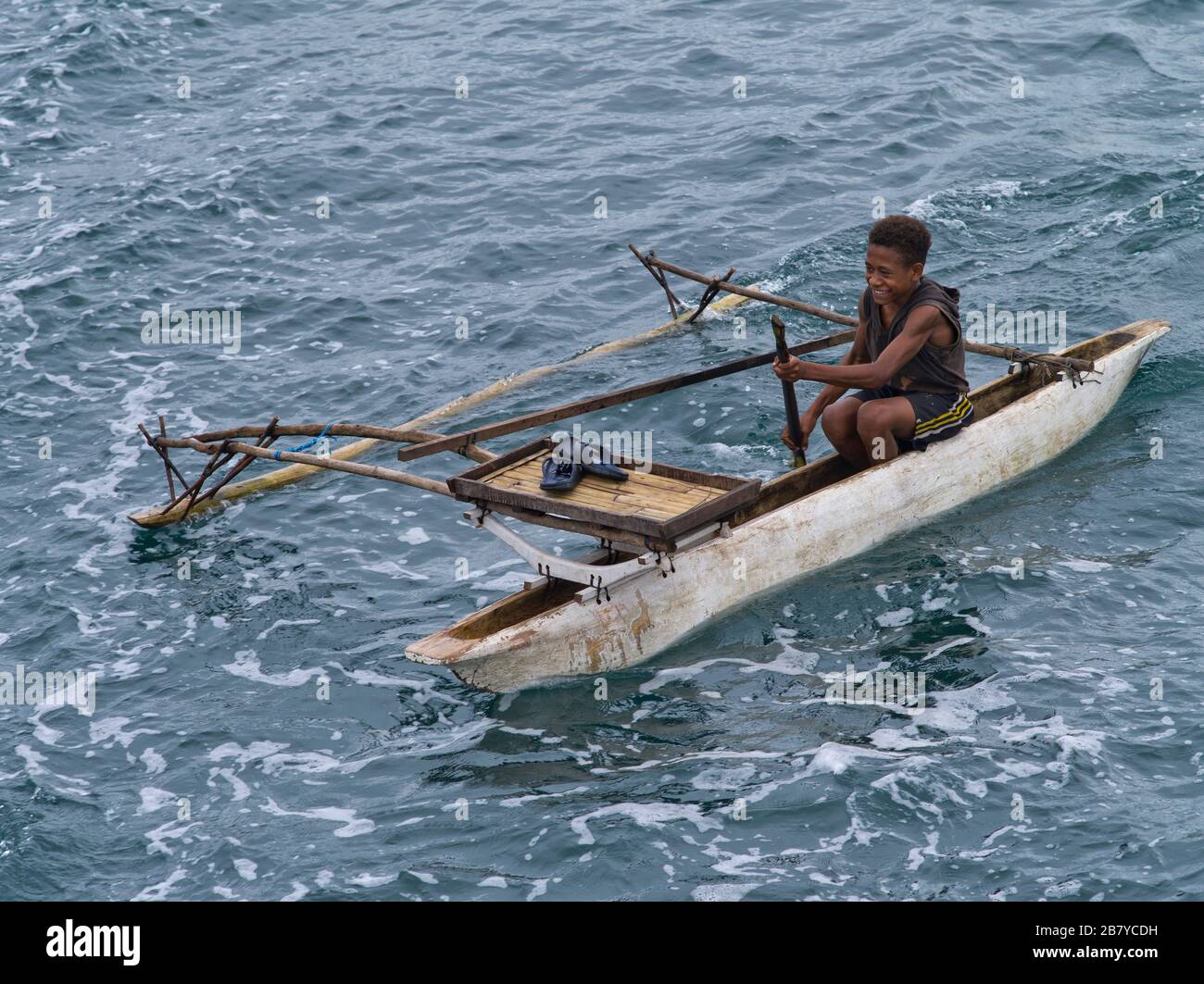 dh Native canoe outrigger MADANG PAPUA NEW GUINEA Local smiling boy boat in boat canoes png canoeing Stock Photo