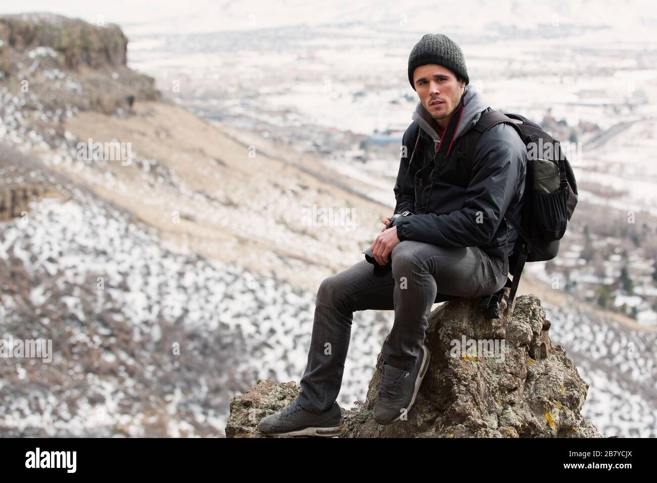 adventurous photographer resting on a rock in the mountains Stock Photo