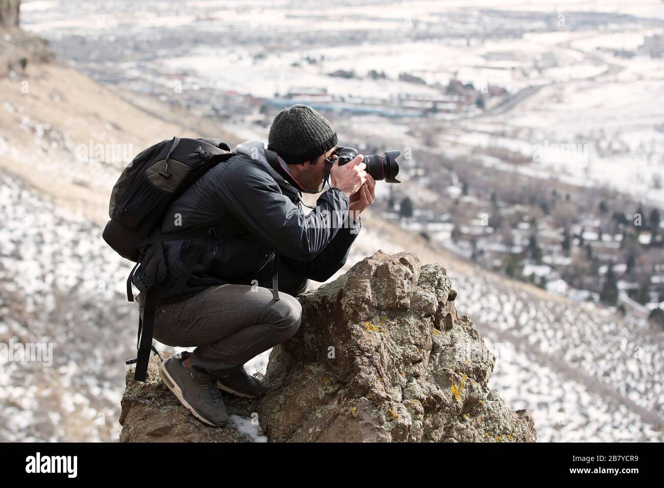 adventure photographer taking a risky photo in the mountains Stock Photo