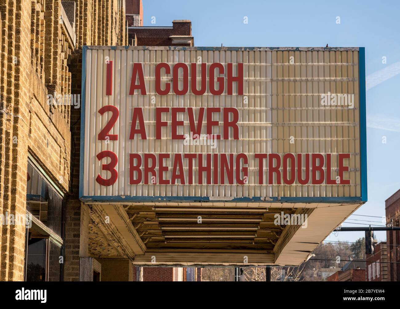 Cinema billboard with three main symptoms or signs of a coronavirus or Covid-19 infection of coughing, feverish and trouble with breathing Stock Photo