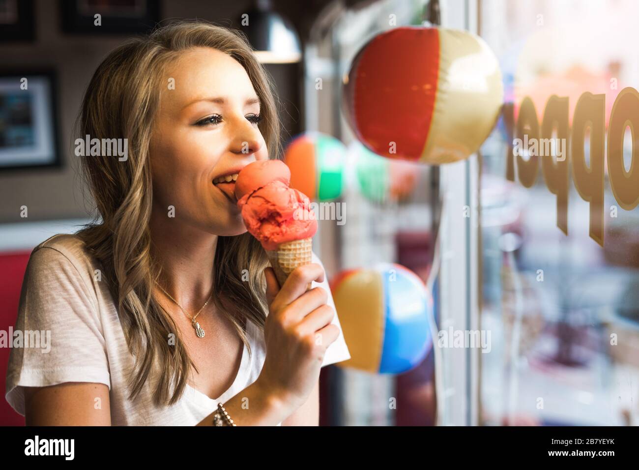 young woman licking an ice cream cone on a summer evening Stock Photo