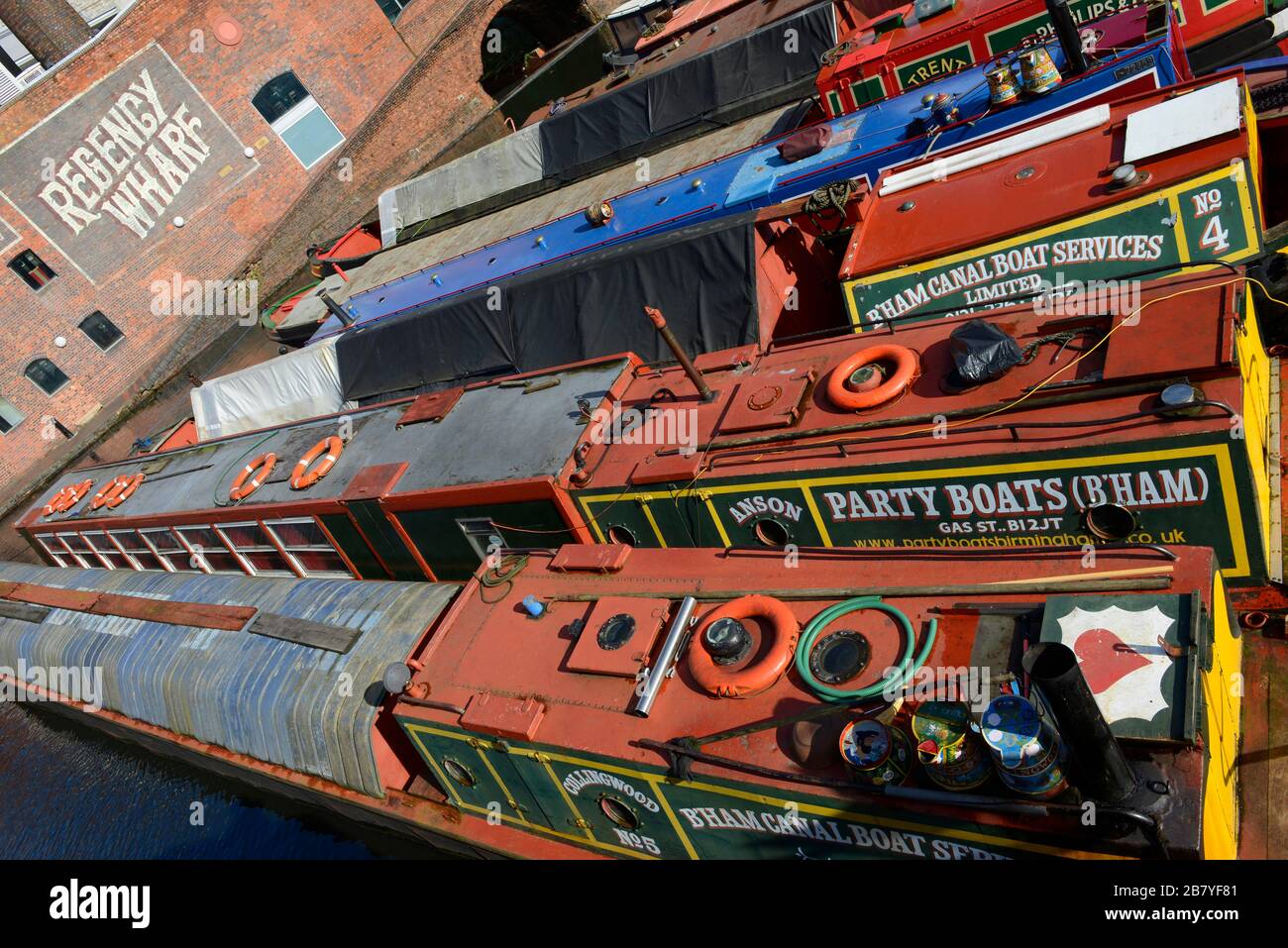 Many colourful canal boats are moored in Gas Street Basin on Birmingham