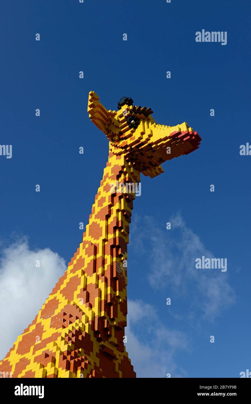 A huge Lego model giraffe stands outside the Lego store in central Birmingham, UK, on a sunny day Stock Photo