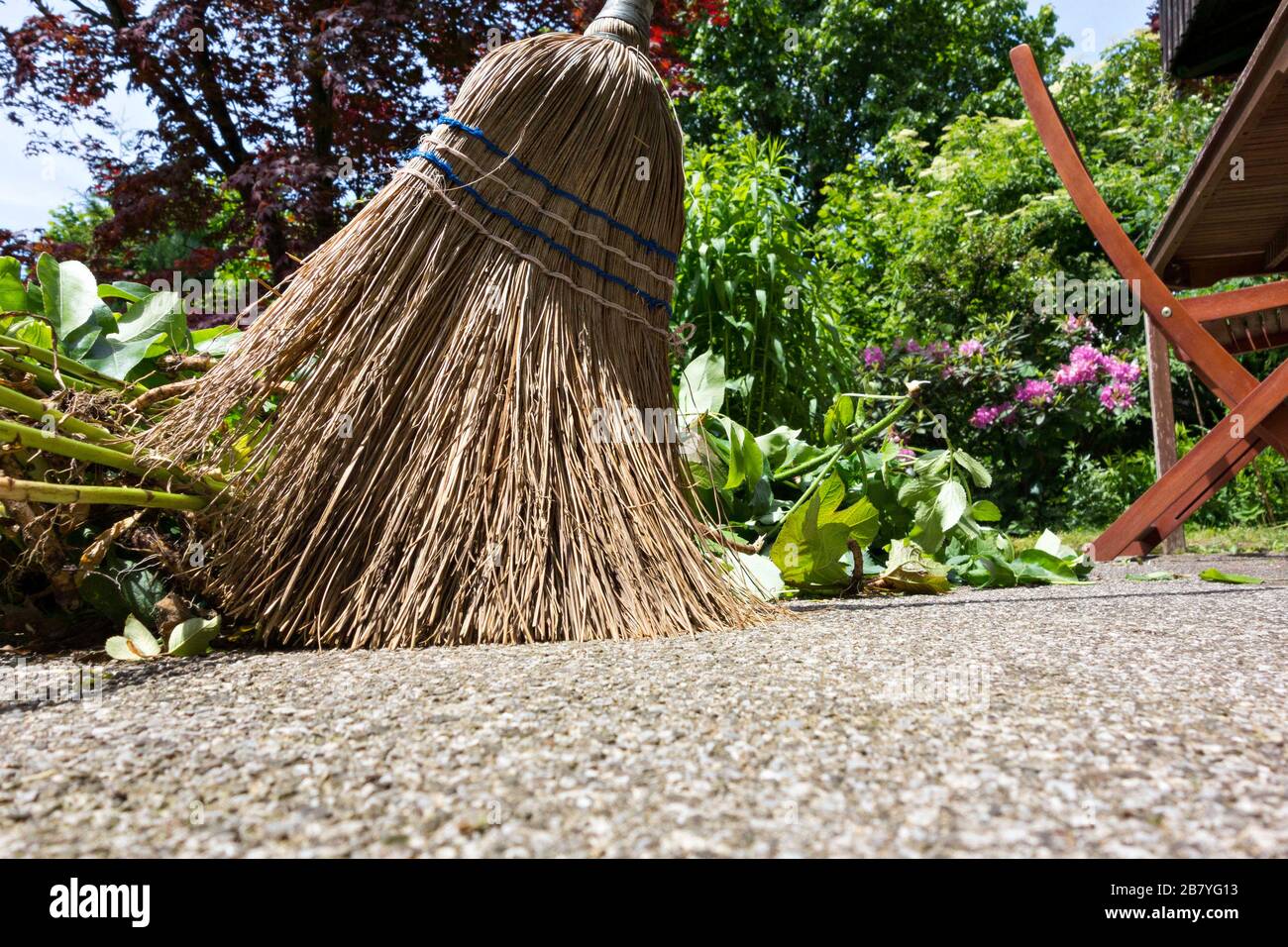 Straw Broom sweeping away garden cuttings on terrace, Chiemgau, Upper Bavaria Germany Europe Stock Photo